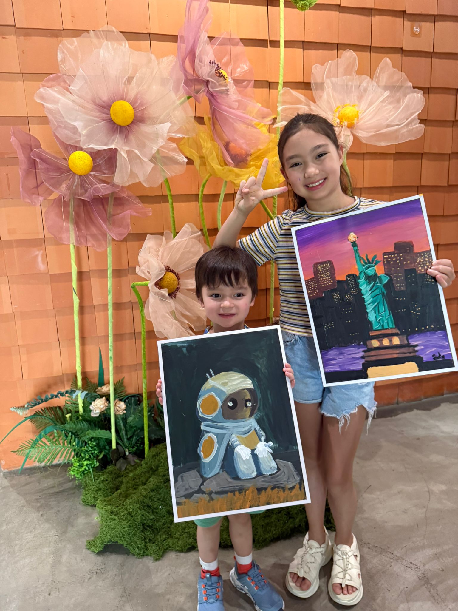 Chris and Sadie holding their paintings